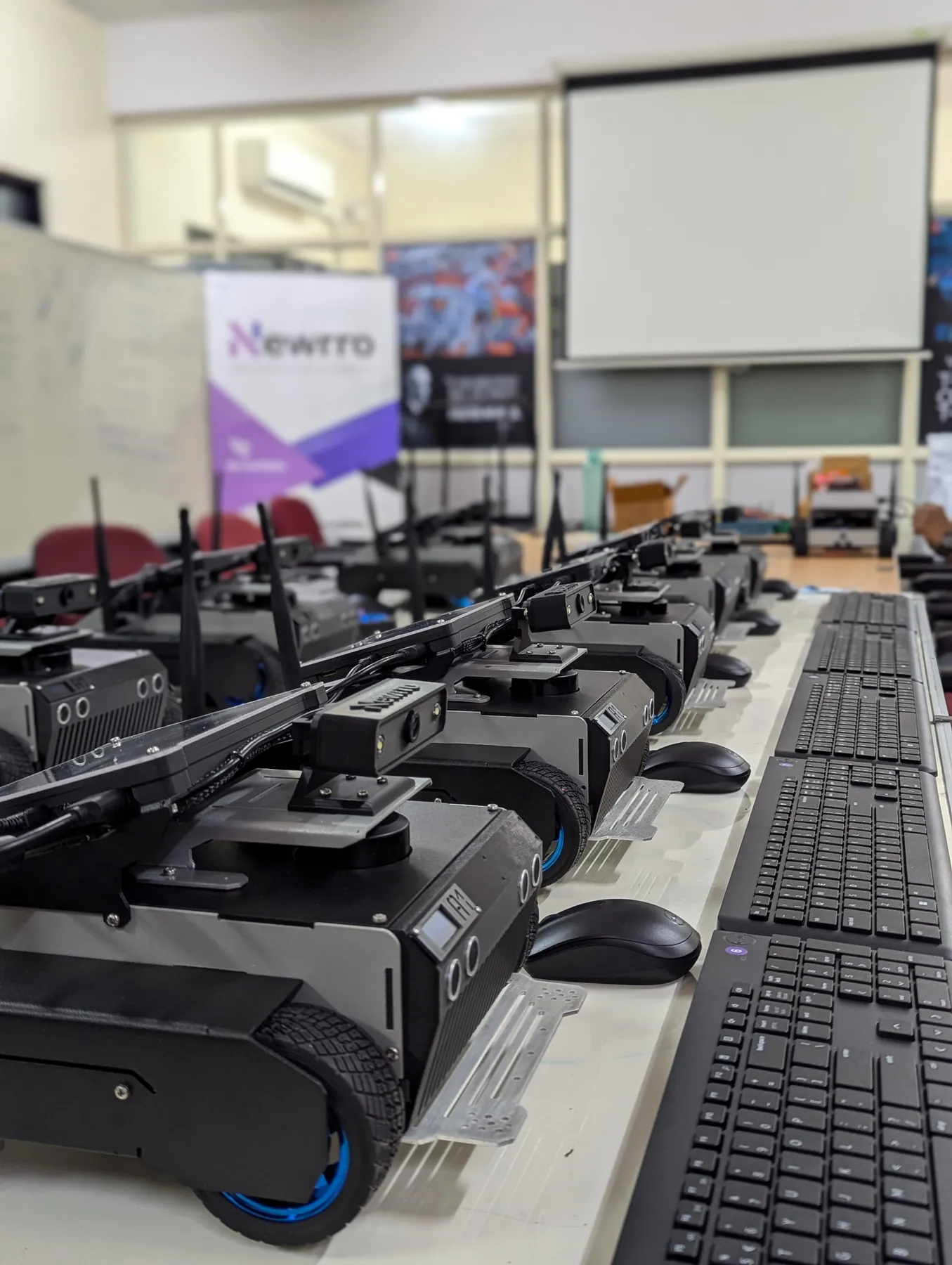 A row of ARJUNA robots and keyboards laid out for a hands-on training session